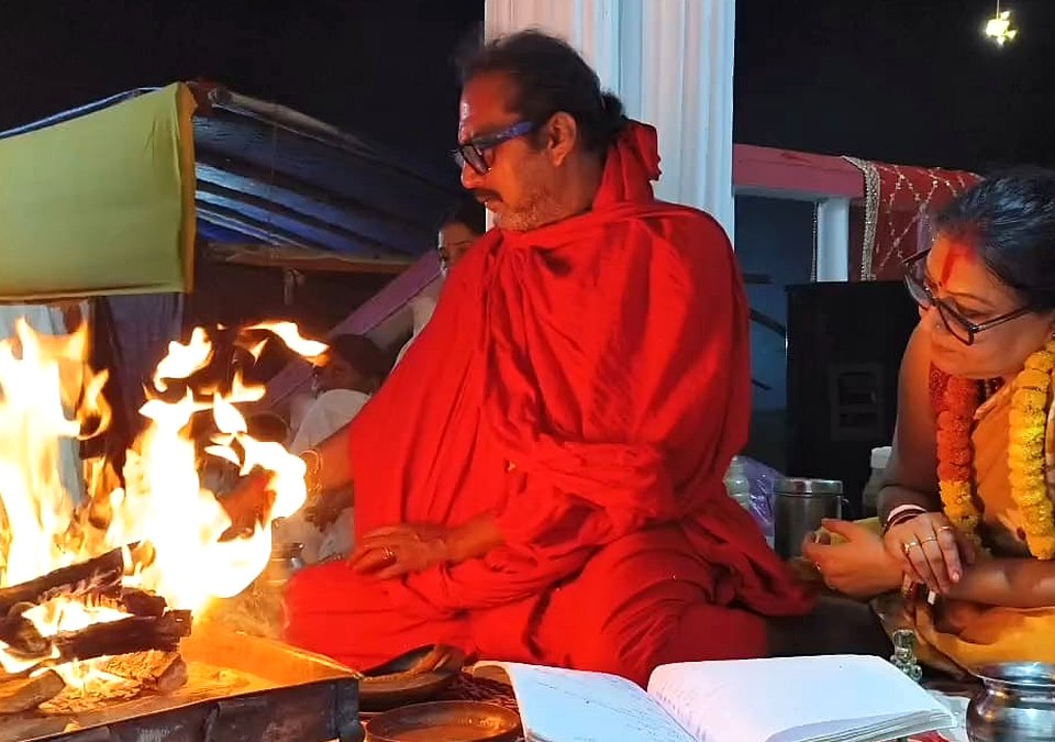 Sri Meenananda Tirthanath and Guruma seated at night homa, in robes.