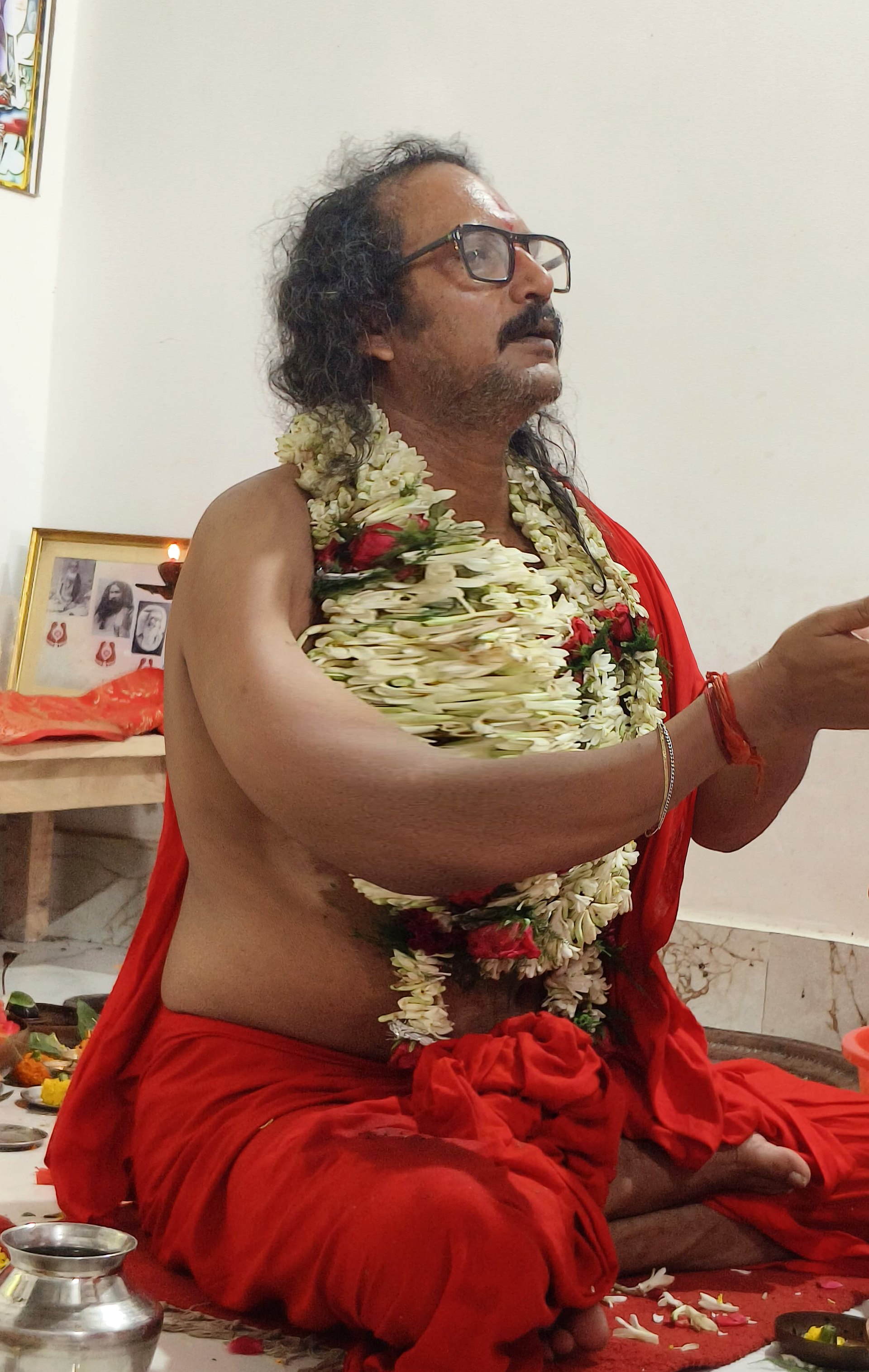 Sri Meenananda Tirthanath in seated puja, offering with joined hands.