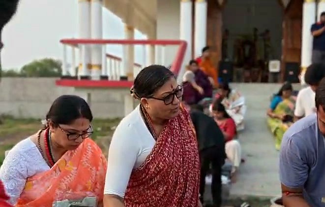मन्दिर की सीढ़ियों पर पैक करती और देती स्त्रियाँ